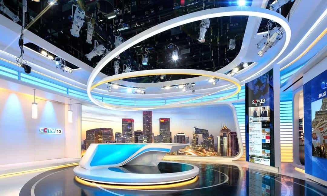 Modern news studio with cityscape backdrop.