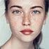 Close-up portrait of a woman with freckles.